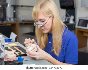 Dental Lab Technician Applying Porcelain To Dentition Mold In A Lab