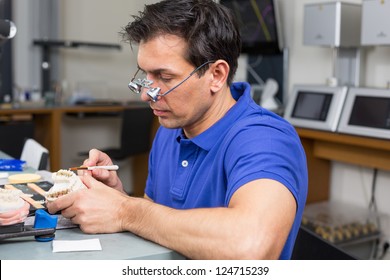 Dental Lab Technician Applying Porcelain To Dentition Mold