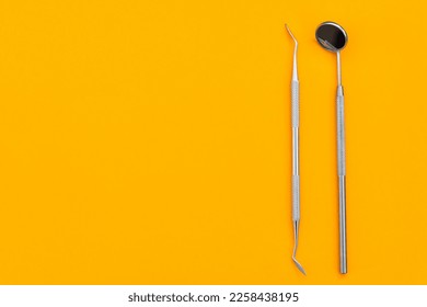 Dental mirror on an orange background. Medical tool - Shutterstock ID 2258438195