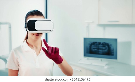 Dental professional using virtual reality in a clinic. A young dental professional wearing virtual reality goggles and red gloves interacts with a virtual interface in a modern clinic. - Powered by Shutterstock