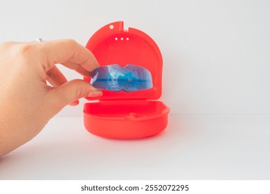 Dental simulator for teeth alignment. dental trainer equalize growing teeth, correct bite Teen and child orthodontic oral health care concept. Blue mouthguard on white background