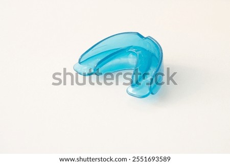 Dental simulator for teeth alignment. dental trainer equalize growing teeth, correct bite Teen and child orthodontic oral health care concept. Blue mouthguard on white background