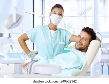 Dental Surgeon And Patient Smiling Happy After Dental Checkup, Looking At Camera.