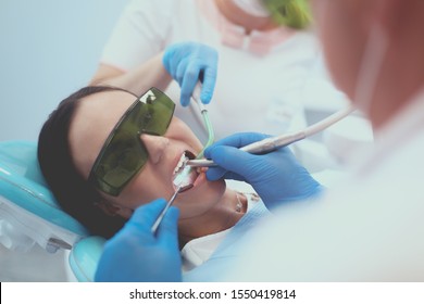 Dental team and patient at dentist's surgery - Shutterstock ID 1550419814