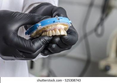 Dental Technician Holding A Monolithic Zirconia Restorations Full Arch Implant  Supported With The Ceramic Load In Vestibular.