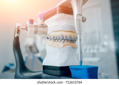 Dental Technician Working With Articulator In Dental Lab