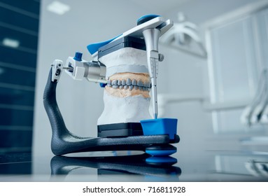 Dental Technician Working With Articulator In Dental Lab