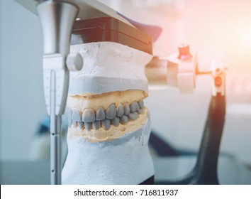 Dental Technician Working With Articulator In Dental Lab