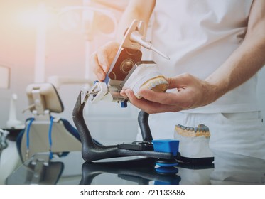 Dental Technician Working With Articulator In Dental Lab