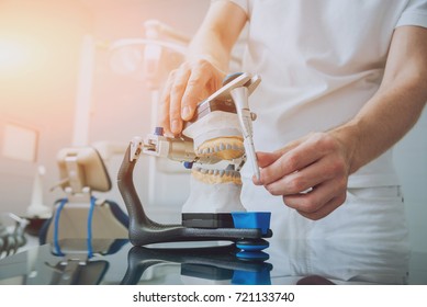 Dental Technician Working With Articulator In Dental Lab