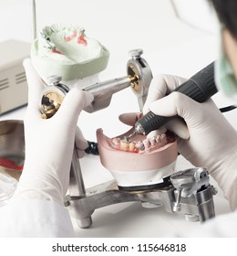 Dental technician working with articulator in dental laboratory - Shutterstock ID 115646818