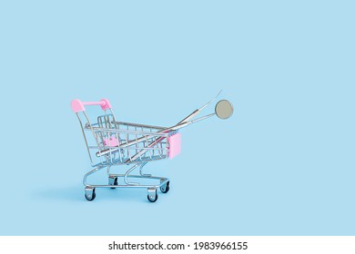 Dental Tools Mirror And Probe In Shop In Cart Basket Trolley On Blue Background. Medical Supplies. Delivery, Purchase, Sale, Shopping Online. Oral Care. Examination And Treatment Of Teeth. Copy Space