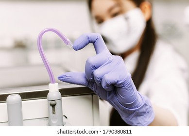 Dental treatment, healthcare and dentistry concept. The woman's hand shows the heart together with the saliva ejector - Shutterstock ID 1790380811