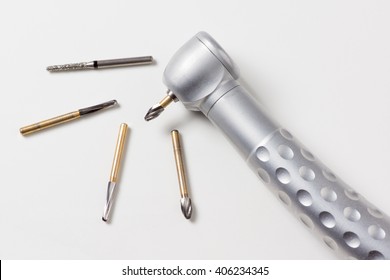dental turbine handpiece with burs on a white background