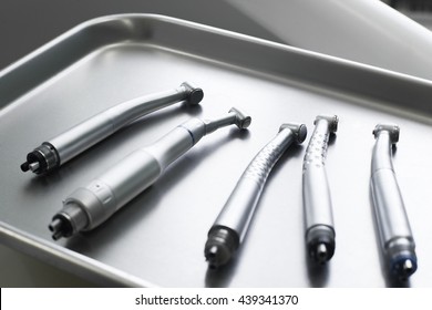 Dental turbine handpieces on metal tray closeup. Top view on ready for using set of dental tuebine handpieces on mesical tray.