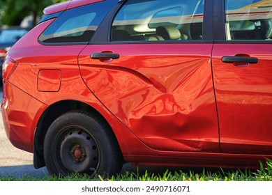 Dented door of car after accident, collision impact on vehicle. Impact damage. Damaged car rear door, huge dents after road collision
