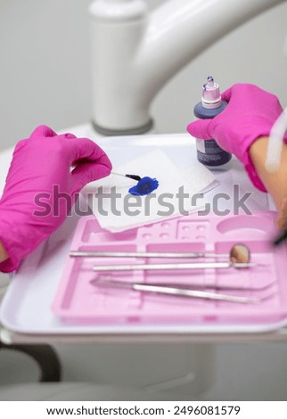 Dentist applying plaque disclosing solution to child's teeth. High quality photo