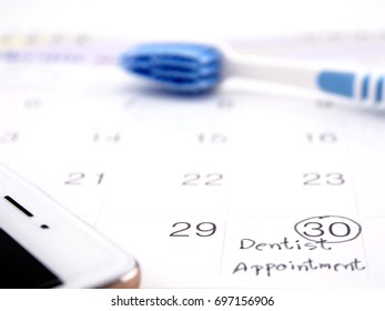 Dentist Appointment Reminder On Calendar With Tooth Brush And Mobile Phone ; Medical Concept