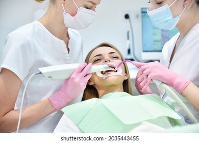 Dentist and assistant scaning patient's teeth with  3d scanner. Health care and stomatology concept - Shutterstock ID 2035443455