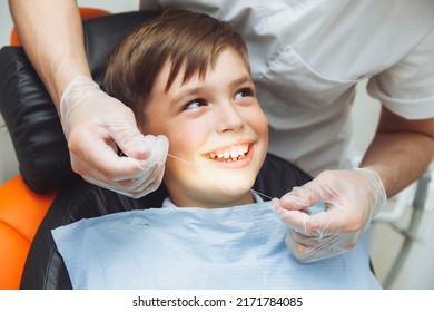 The Dentist Brushes The Boy's Teeth With Dental Floss. Oral Hygiene In Children. Pediatric Dentistry. Flossing Your Teeth.