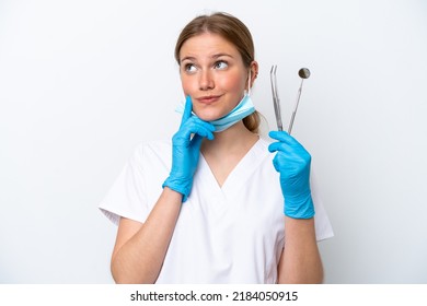 Dentist caucasian woman holding tools isolated on white background thinking an idea while looking up