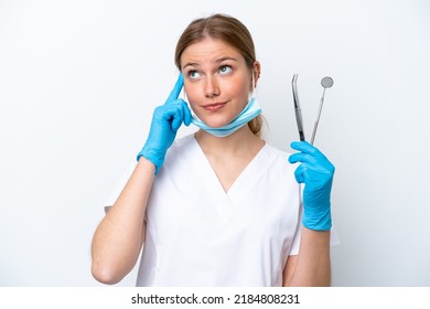 Dentist caucasian woman holding tools isolated on white background having doubts and thinking