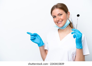 Dentist caucasian woman holding tools isolated on white background pointing finger to the side - Powered by Shutterstock