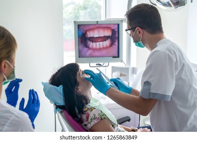 Dentist Checking Patient's Teeth With Intraoral Camera