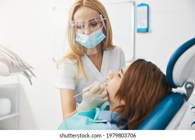 Dentist Clinic Employee Examining Teeth Of Minor Patient