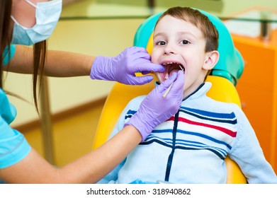 Dentist curing a child patient in the dental office in a pleasant environment. There are specialized equipment to treat all types of dental diseases in the office.