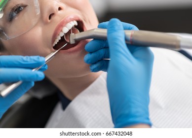 Dentist Curing Oral Cavity Of Cheerful Woman