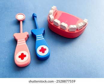 Dentist Dai, February 1st. Wooden teeth and dental instruments on a blue background. Dental health concept. Pediatric dentist. Top view - Powered by Shutterstock