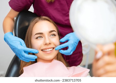 Dentist demonstrates the perfect smile of the patient after implatation of dental veneers or teeth whitening.  - Powered by Shutterstock