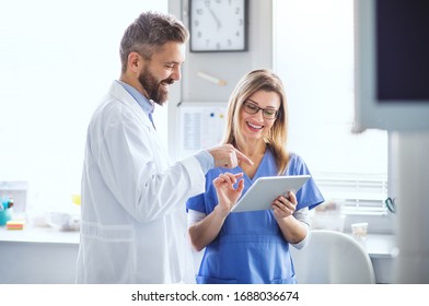 A dentist with dental assistant in modern dental surgery, working. - Powered by Shutterstock