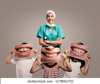 médico dentista con hijos sosteniendo una foto de una boca sonriente