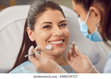 Dentist doctor, dentistry professional, examining the teeth of a happy patient during a visit to the clinic. Dental care session, regular check up and treatments in maintaining oral health. - Powered by Shutterstock