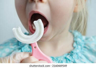 dentist, doctor teaches child, small patient to silicone brush capa his teeth, closeup kid's teeth, concept pediatric dentistry, dental treatment, correction of occlusion, oral care, caries prevention - Shutterstock ID 2160469549