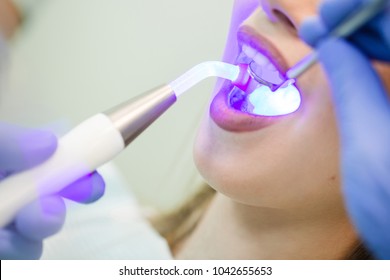 Dentist Doing Procedure With Dental Curing UV Light In Clinic