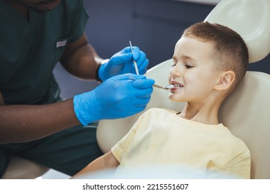 Dentist Doing Regular Dental Check-up To Little Boy. Close Up Of Boy Having His Teeth Examined By A Dentist. Cute Boy Smiling While Teeth Exam . Happy Boy Sitting In Dentists Chair 