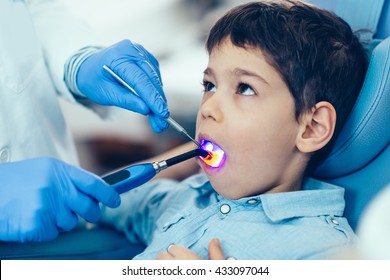 Dentist Drying Of The Dental Filling Boy's Tooth