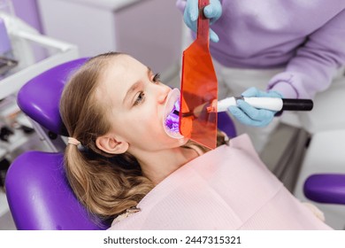 Dentist drying dental filling with curing light at medical clinic - Powered by Shutterstock