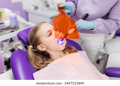 Dentist drying dental filling with curing light at medical clinic. - Powered by Shutterstock