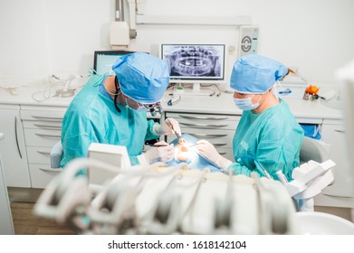 Dentist During A Dental Intervention With A Patient. Dental Clinic Concept.