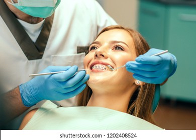 Dentist examine female patient with braces in denal office - Shutterstock ID 1202408524
