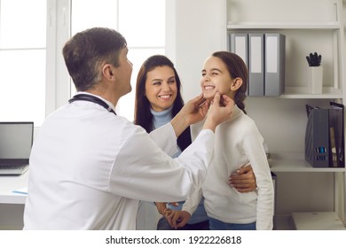 Dentist examines little patient. Happy smiling kid shows good white healthy even teeth to hygienist. Mom and child seeing orthodontist to fix bite and align jaws correctly at early age, in childhood - Powered by Shutterstock