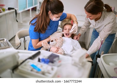 Dentist examines child’s teeth with mirror  - Powered by Shutterstock