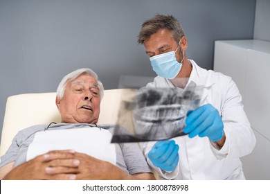 Dentist Examining Dental Xray Of Old Senior