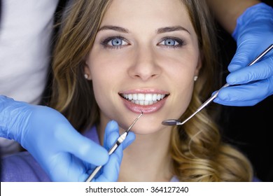 Dentist examining a patient's teeth in the dentist. - Powered by Shutterstock