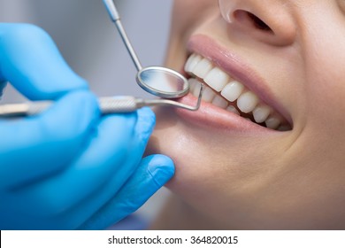 Dentist examining a patient's teeth in the dentist. - Shutterstock ID 364820015