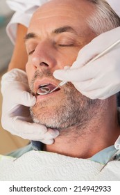 Dentist Examining A Patients Teeth In The Dentists Chair At The Dental Clinic